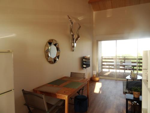 une salle à manger avec une table et une vue sur un patio dans l'établissement Appartement neuf 6 couchages 50 metres de la plage, à Gruissan