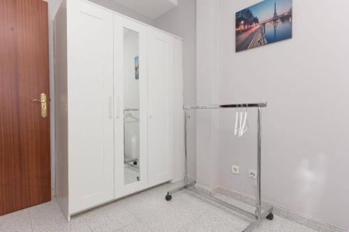 un armario blanco con una puerta de cristal en una habitación en MalagaOnBeach 1 - Two bedrooms - up to 7 people - 10 meters beach, en Málaga