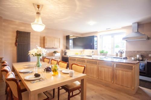 a kitchen with a wooden table and a dining room at Willa Mandala in Dziwnówek