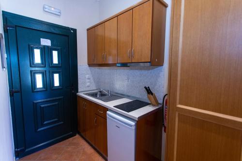 a kitchen with a blue door and a sink at Petros Penthouse in Parga
