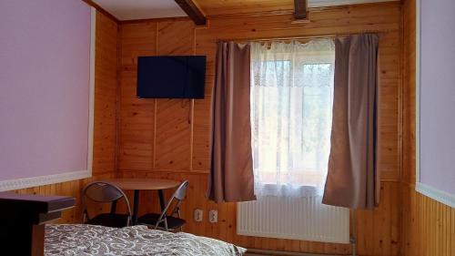 a bedroom with a bed and a window and a table at Мамина Хата in Mykulychyn