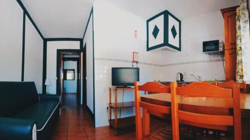 a living room with a couch and a television at Camping Villa Park Zambujeira do Mar in Zambujeira do Mar