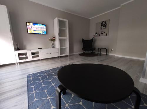 a living room with a table and a tv at Apartament Centrum Bartoszyce in Bartoszyce
