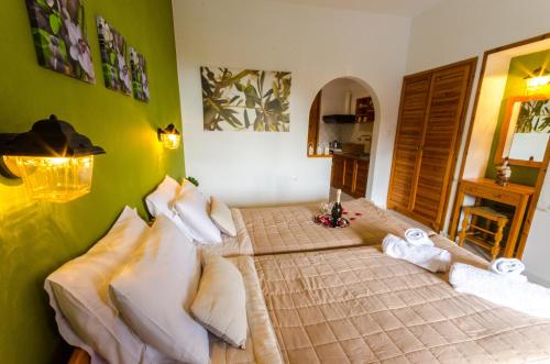 een slaapkamer met 2 bedden in een kamer met groene muren bij Olive Grove View in Skiathos-stad