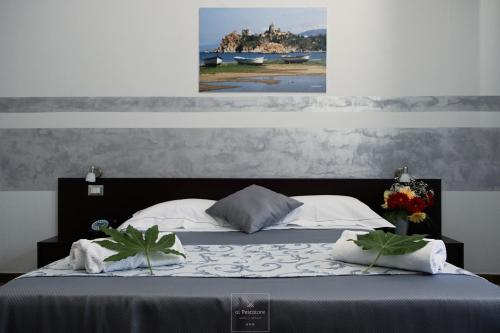 a bedroom with a bed with a painting on the wall at Al Pescatore in Cefalù