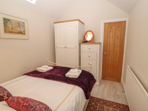 a bedroom with a bed with two towels at Fir Tree Cottage in Criccieth