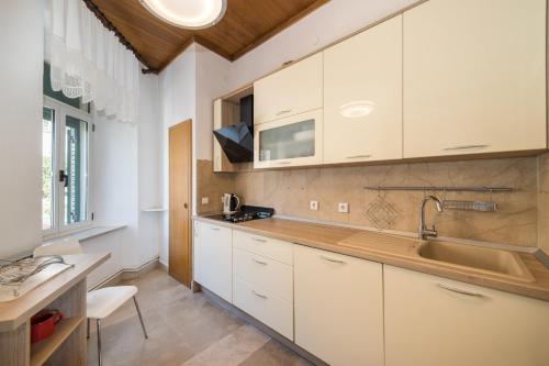 eine Küche mit weißen Schränken und einem Waschbecken in der Unterkunft Apartment Riva in Makarska