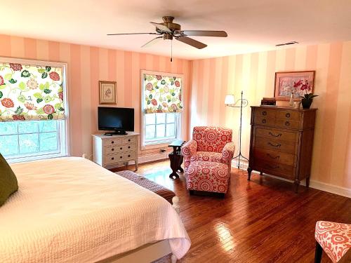a bedroom with a bed and a chair and a television at The Lily Inn - Burlington in Burlington