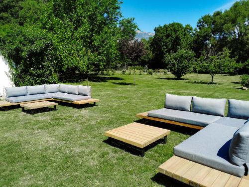three couches and picnic tables in the grass at Maison San Giovanni in Corte
