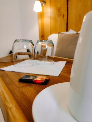 a table with two glasses and a cell phone on it at Maison San Giovanni in Corte