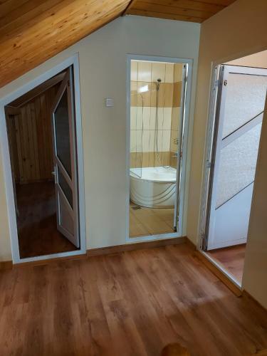 a bathroom with a tub and a toilet and a door at Casa Atlas in Eforie Sud