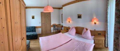 ein Schlafzimmer mit einem Bett mit rosa Kissen in der Unterkunft Apartements Birkenhof in Maria Alm am Steinernen Meer