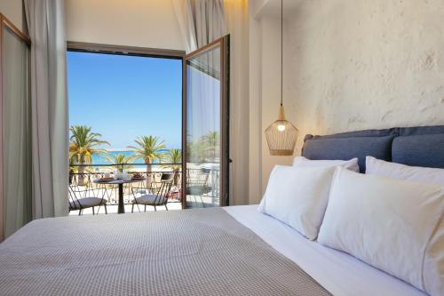 a bedroom with a bed with a view of a patio at Μuses Suites in Rethymno