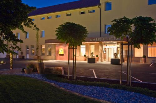 um hotel com árvores em frente a um edifício em Ambient Hotel em Domžale