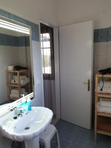 bagno con lavandino bianco e specchio di Monambeles Villas a Svoronáta