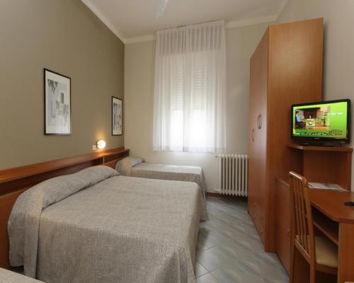 a hotel room with two beds and a television at Hotel Ravenna in Ravenna