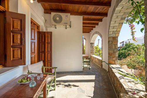 an outdoor patio with a table with a bowl of fruit at VENTUS Studios in Khóra Sfakíon