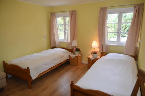two beds in a room with two windows at Ferienwohnung am Dorm in Süpplingenburg