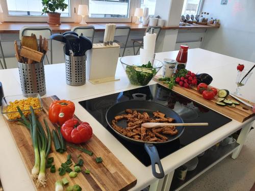 a frying pan on a stove with vegetables on a cutting board at Business Hotel Wiesbaden PRIME in Wiesbaden