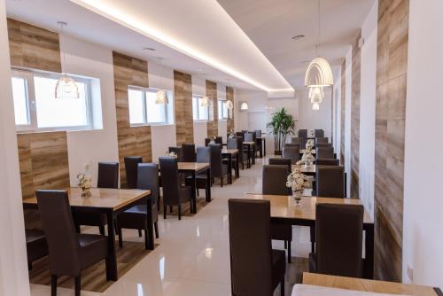 a restaurant with wooden walls and tables and chairs at Princ Apartment in Niš