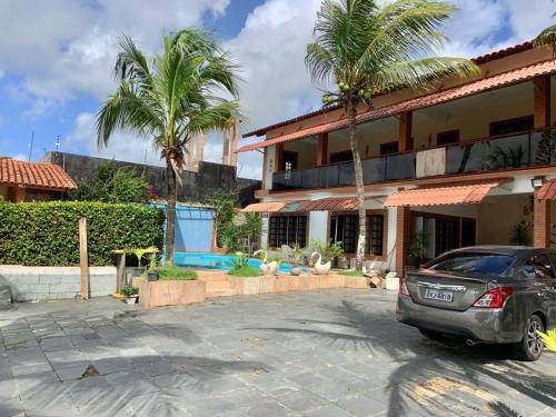 a car parked in front of a building with palm trees at Casa Perfeita para suas férias in Salinópolis