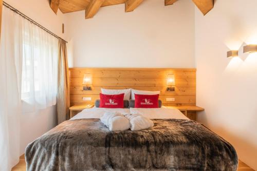 a bedroom with a large bed with red pillows at Löwen Chalets in Seefeld in Tirol