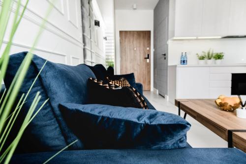 a living room with a blue couch and a table at Hypnotize Apartment Glamour in Konin