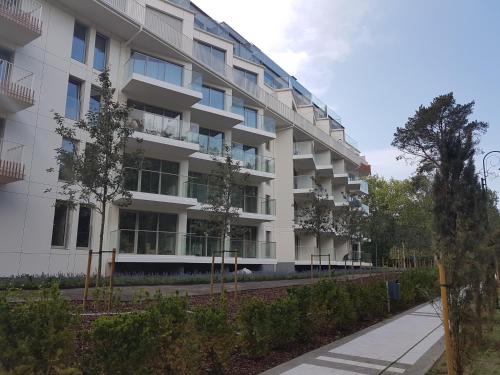 an apartment building with trees in front of it at Albus 112 ApartPark in Świnoujście