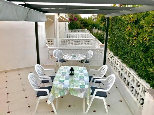 a table and chairs on a patio with an umbrella at Adosado de 140m2 con terraza a 50 m de la playa in Denia