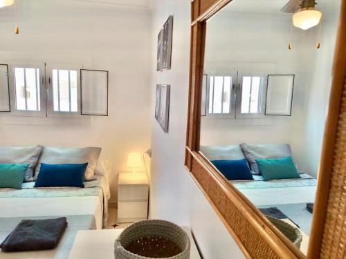a living room with a mirror and a couch at Adosado de 140m2 con terraza a 50 m de la playa in Denia