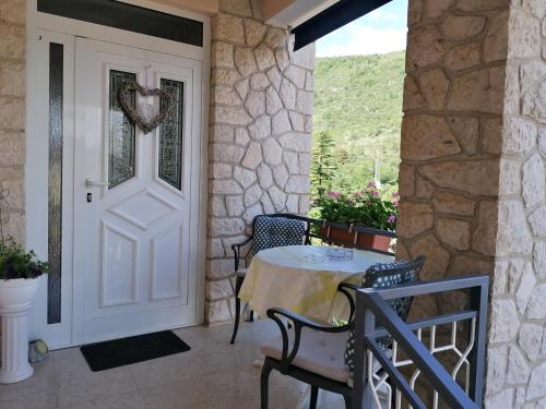 a door to a patio with a table and chairs at Apartments Tonka Franković in Mošćenička Draga