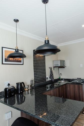 a kitchen with two hanging lights over a counter at Casa Leitao Lodge in Phalaborwa