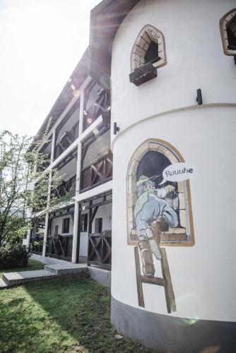 a painting of a man on a ladder on the side of a building at Toschis Station-Motel-Wirtshaus-an der Autobahn-Bowling in Zella-Mehlis