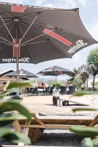 a black umbrella sitting on a picnic table at Toschis Station-Motel-Wirtshaus-an der Autobahn-Bowling in Zella-Mehlis