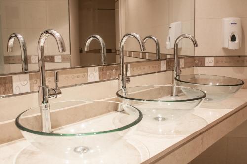 due lavandini in un bagno con due rubinetti di HR Luxor Hotel Buenos Aires a Buenos Aires
