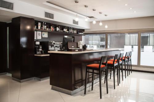 um bar com bancos num balcão num restaurante em HR Luxor Hotel Buenos Aires em Buenos Aires