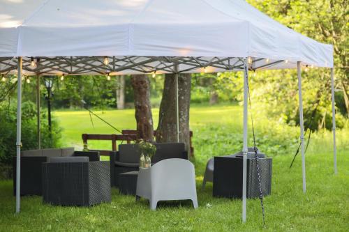 a white tent with chairs and tables in the grass at Hostel Szczelinka in Pasterka