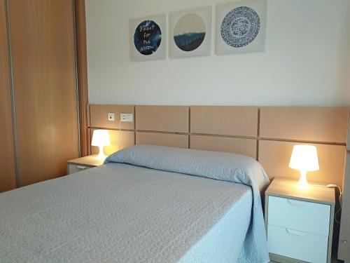 ein Schlafzimmer mit einem Bett und zwei Lampen an Tischen in der Unterkunft ACV - Vistamar III-1ª línea planta 2 Frontal in Oropesa del Mar