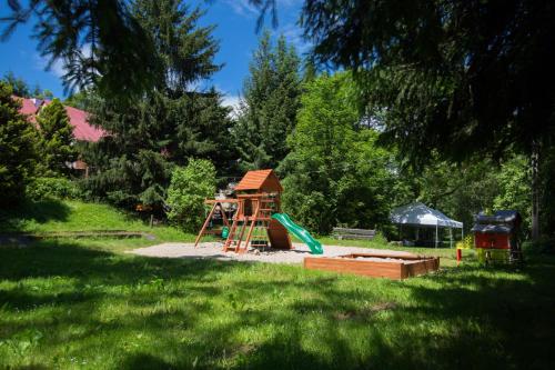 a playground with a slide and a play structure at Hostel Szczelinka in Pasterka