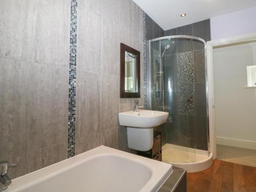 a bathroom with a sink and a shower and a tub at Limers Cottage in Buxton