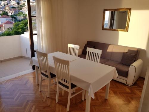 a white table and chairs in a living room with a couch at Apartment Anet with free parking in Dubrovnik