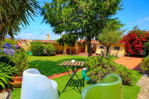 a yard with a table and chairs and a house at Lugar Saloio Sintra in Sintra