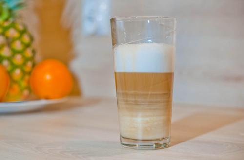 a glass of drink on a table with an orange at PORTY b103 Nadmorskie Tarasy pool sauna parking in Kołobrzeg