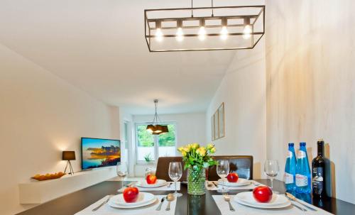 a dining room with a table with chairs and a chandelier at PORTY b103 Nadmorskie Tarasy pool sauna parking in Kołobrzeg