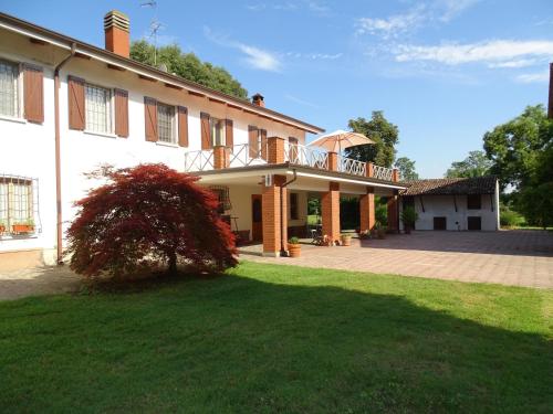 uma casa grande com um deque e um quintal em Corte Isolo em Goito