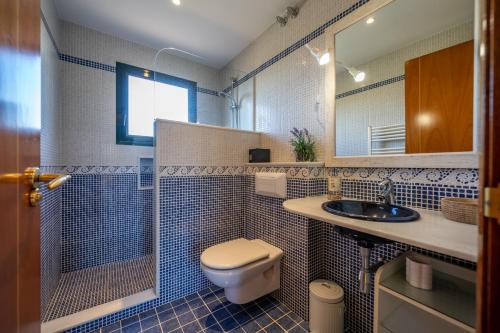 ein Badezimmer mit einem WC, einem Waschbecken und einem Spiegel in der Unterkunft VIlla Jaruco Lux, exclusiva zona residencial con Piscina & Aircon in Lloret de Mar