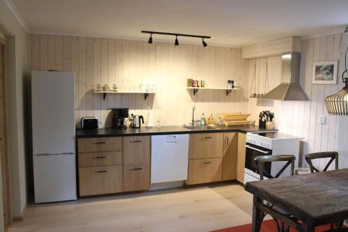 a kitchen with a white refrigerator and a table at Berggatan Villa - lägenhet 2 in Funäsdalen