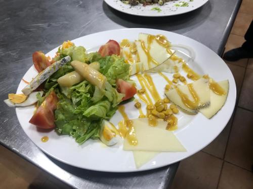 a white plate of food with a salad and cheese at LA CASONA DE PALMIRA in Caín