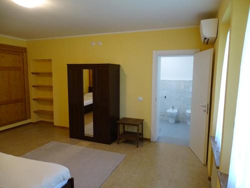 a bedroom with a mirror and a bathroom with a toilet at Corte Isolo in Goito