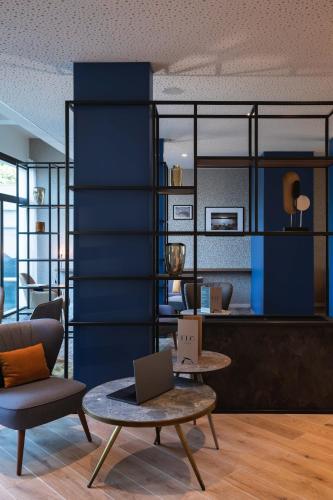 a living room with a table with a laptop on it at Mercure Aix-les-Bains Domaine de Marlioz Hôtel & Spa in Aix-les-Bains